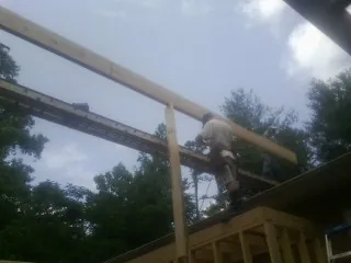 Carpenter setting a ridge beam over a new addition frame — Ice Dam Removal by Roofing Brothers in Bakersfield