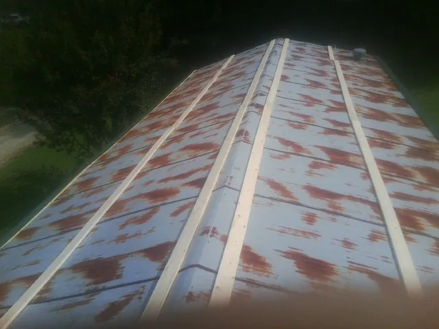 Rusted metal roof panels with new wood purlins before replacement — Storm Damage Roof Repair in Bakersfield by Roofing Brothers